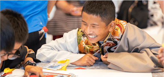 A Tibetan boy smiling broadly during conversation